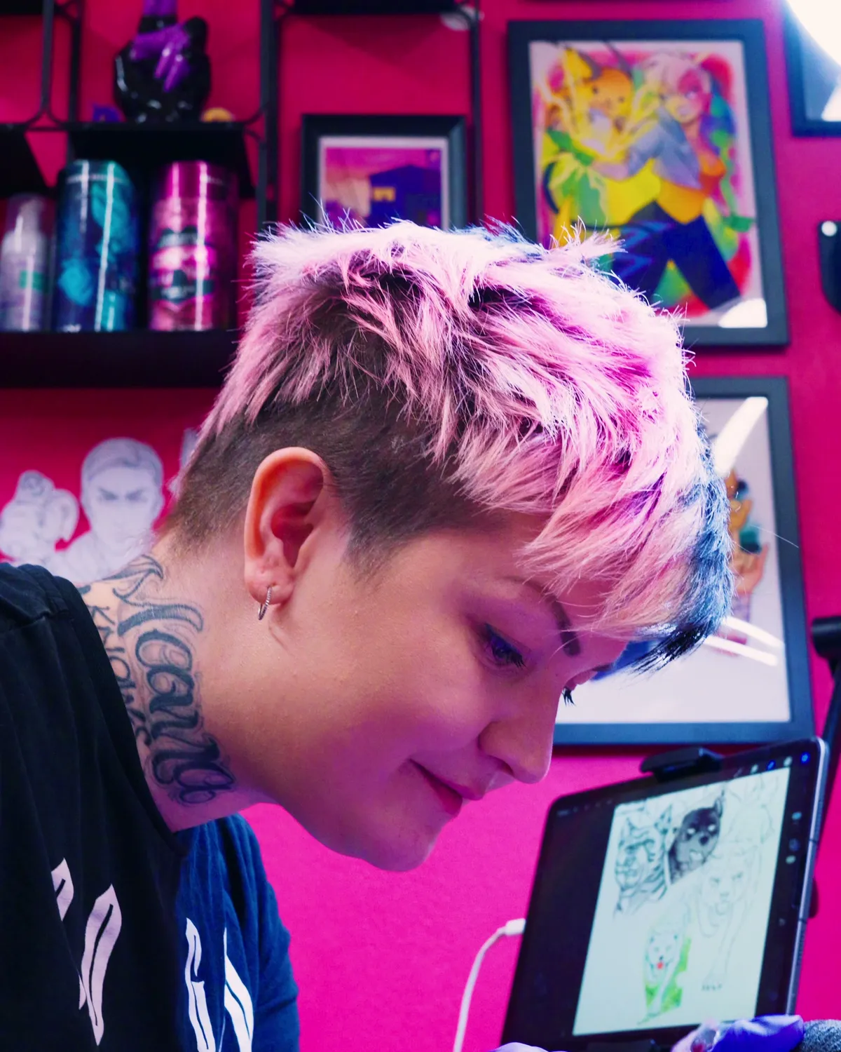 Tatuoija työssään Pretty In Ink -studiolla mallipiirros vieressään