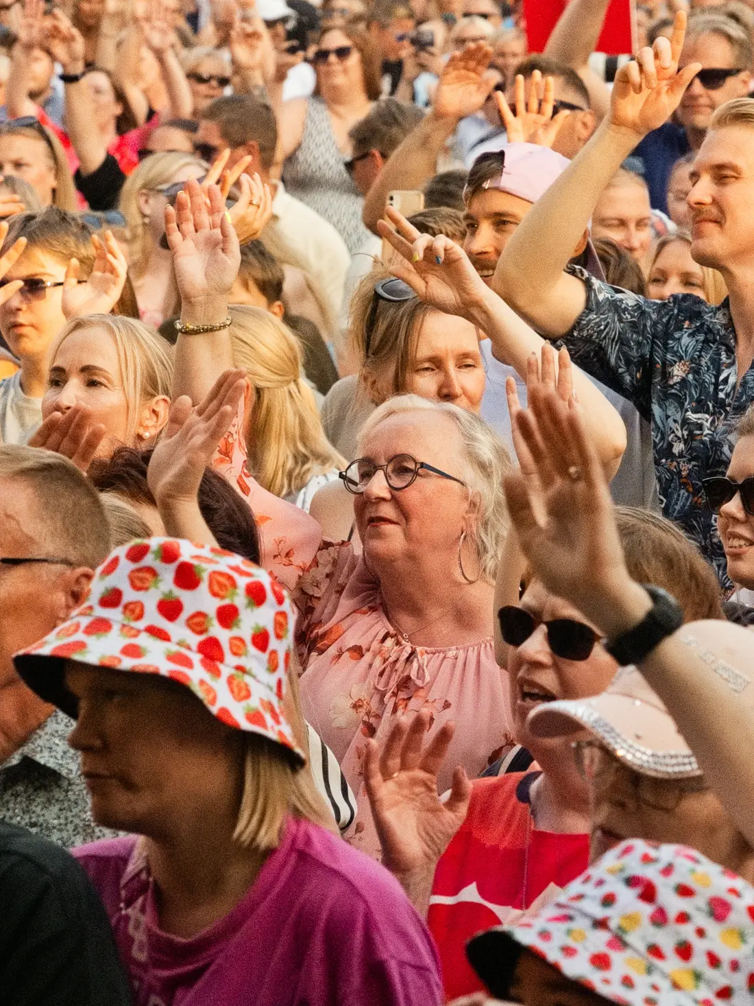 Lähikuva iloisesta yleisöstä keikan aikana