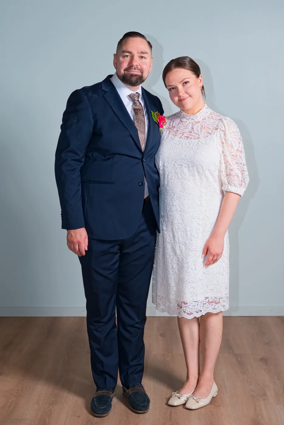 Hääparin potretti vaaleaa seinää vasten
