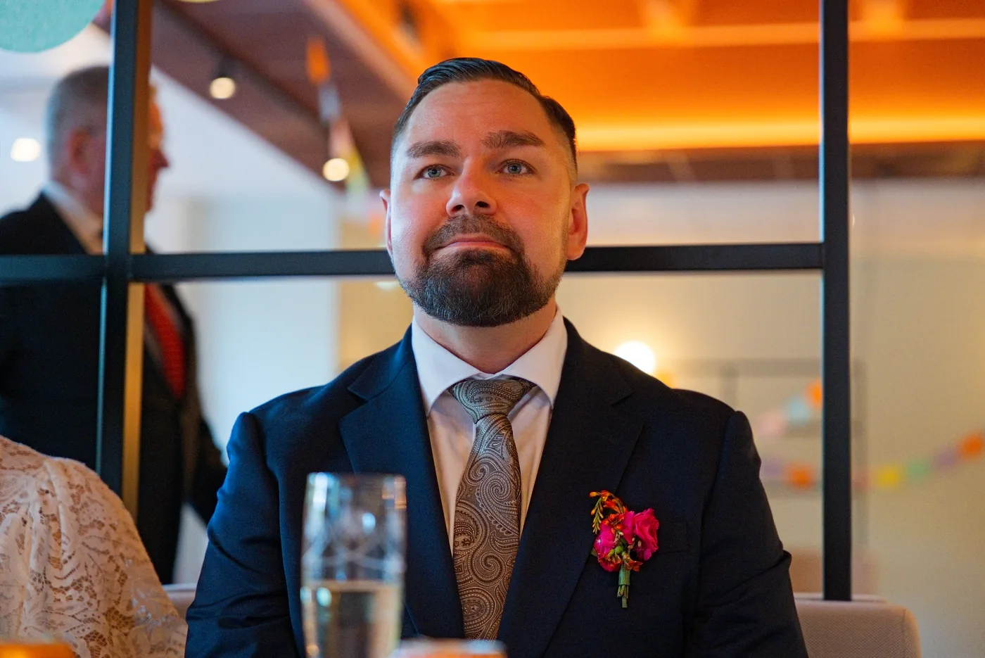 Sulhanen kuuntelee puhetta juhlapöydässä