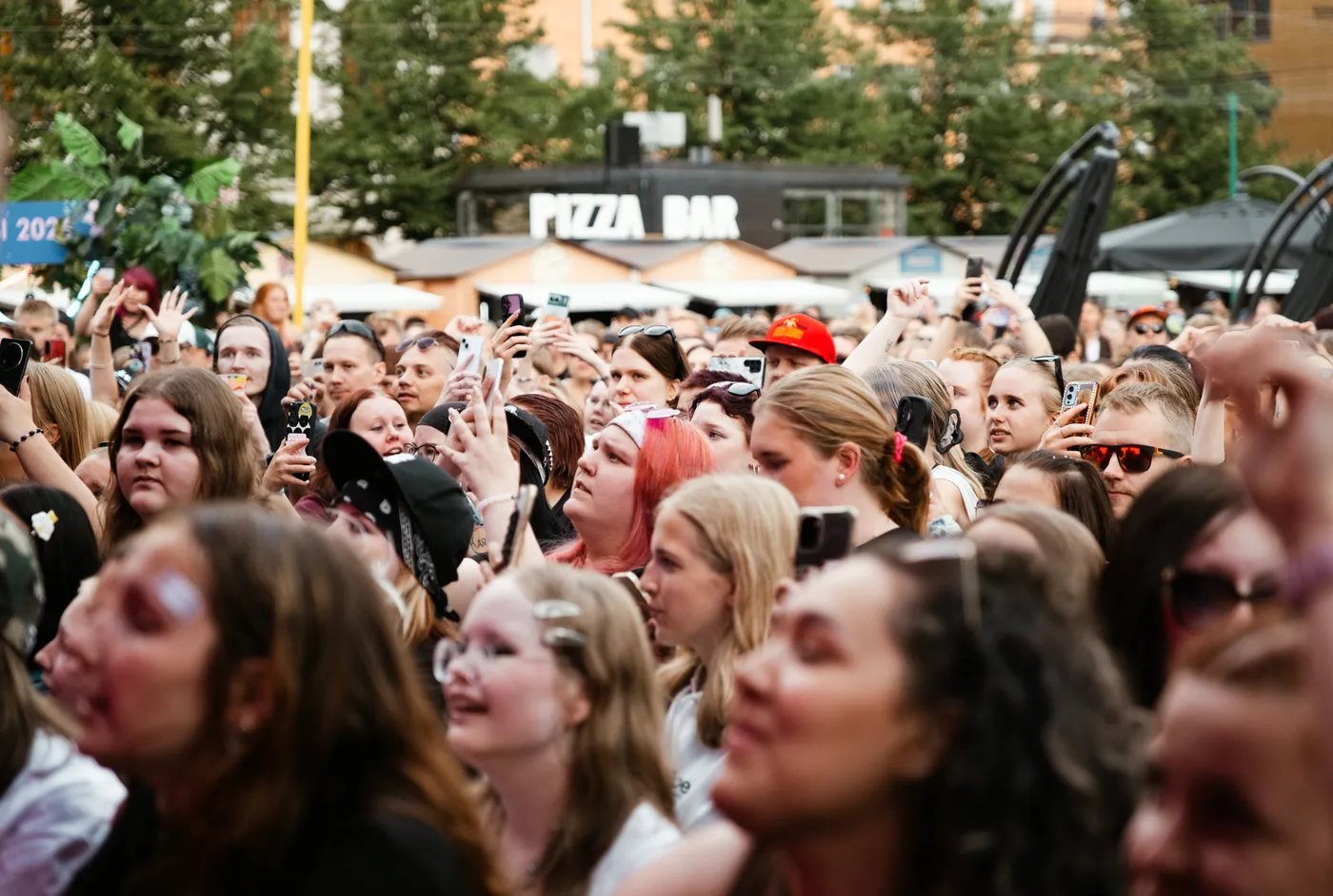 Tapahtuman yleisöä lavan edessä kädet ilmassa